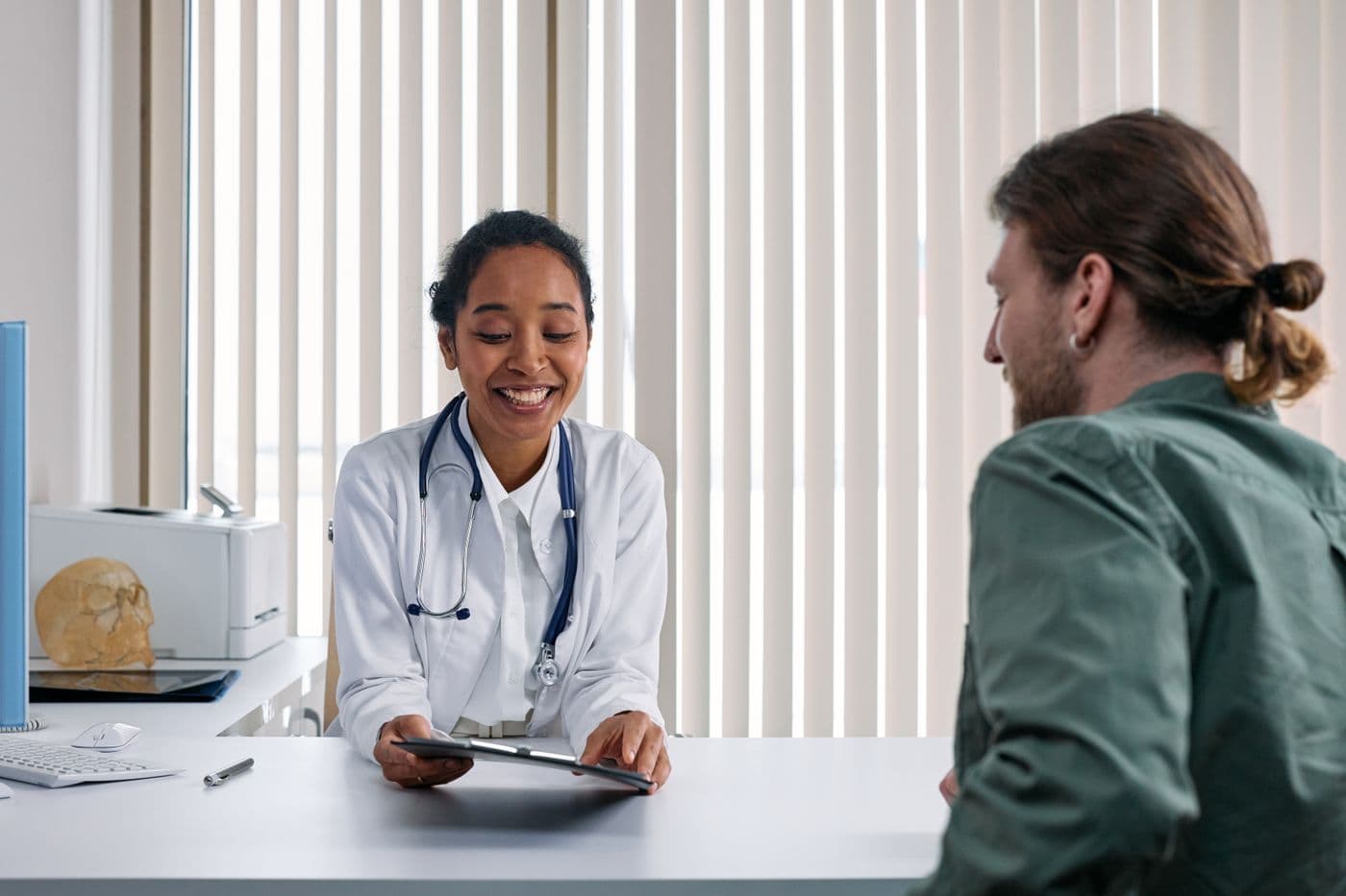 Healthcare professional reviewing patient information on a tablet during an office visit